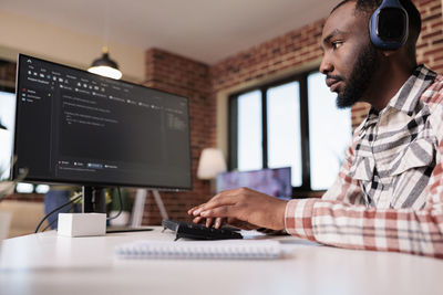 Midsection of man using laptop at office