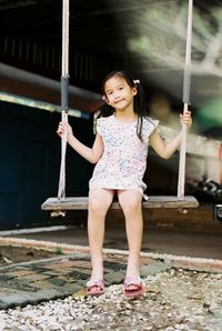 Full length portrait of girl on swing