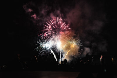 Low angle view of firework display at night