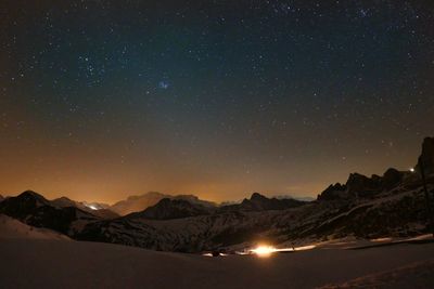 Scenic view of snowcapped mountains against sky at night