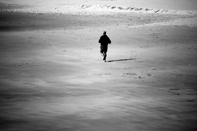 Rear view of man jogging on beach