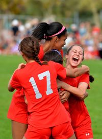 Portrait of smiling young woman playing soccer on field