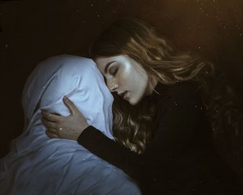 Full length portrait of woman lying down against black background