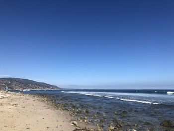 Scenic view of sea against clear blue sky