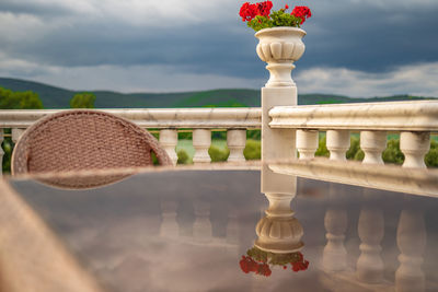 Close-up of white railing by sea against sky