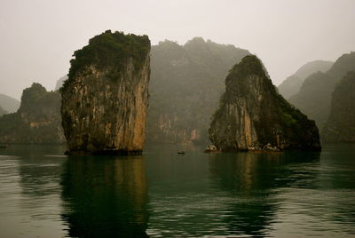 Rock formations in sea against sky