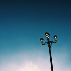 Low angle view of street light against blue sky