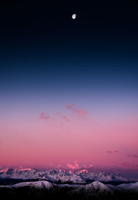 Scenic view of snowcapped mountains against sky at night