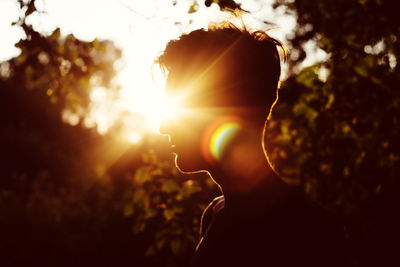 Silhouette man standing against trees during sunset