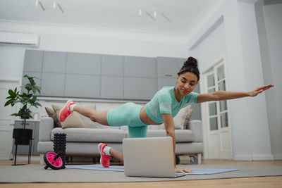 Portrait of young woman sitting on sofa at home