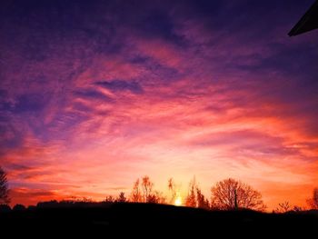 Silhouette landscape against orange sky