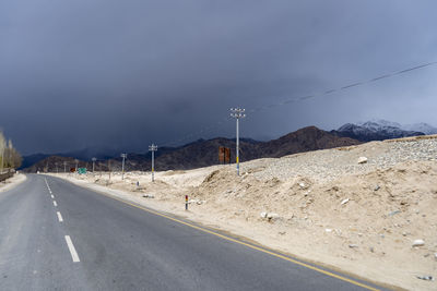Road by mountain against sky
