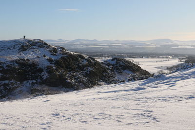 Scenic view of snow covered land against sky