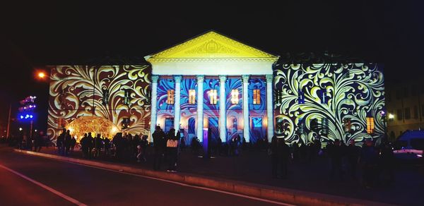 People on illuminated street at night