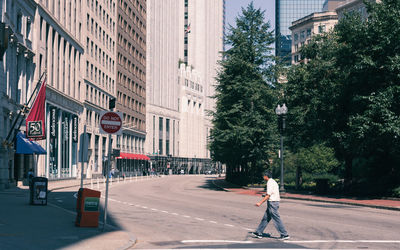 People walking on street against buildings in city