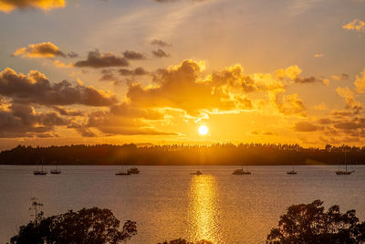 Scenic view of sea against sky during sunset. small sailing boats.