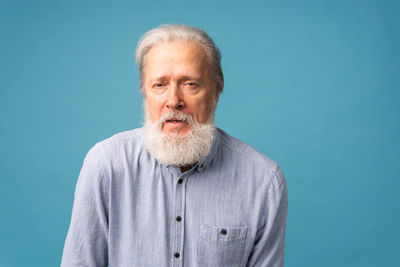 Portrait of young man against blue background