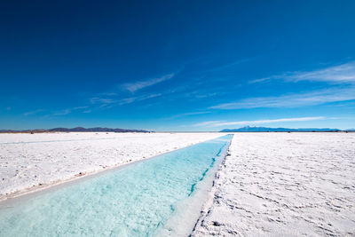 Scenic view of land against blue sky