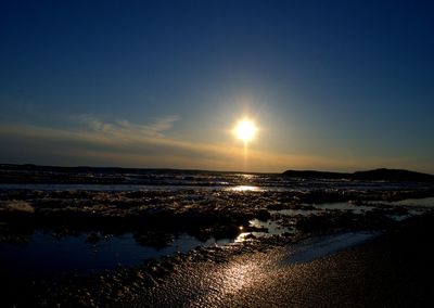 Shallow water on beach at sunset