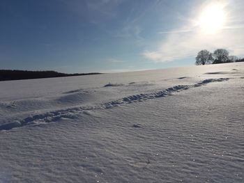 Scenic view of snow covered field against sky