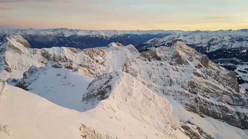 Scenic view of snowcapped mountains against sky during sunset