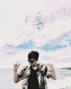 Portrait of young man standing against sky