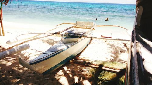 Boat moored on beach against sky