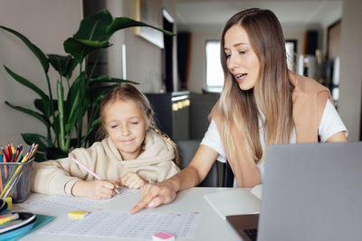 Mother teaching daughter at home