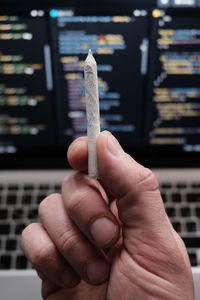 Close-up of hand holding cigarette