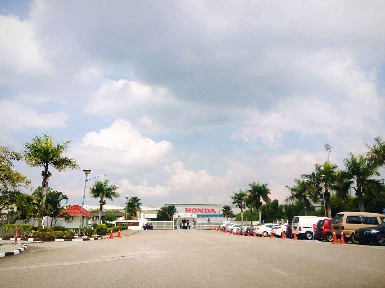 transportation, sky, car, land vehicle, street, tree, road, mode of transport, cloud - sky, building exterior, architecture, built structure, cloudy, palm tree, cloud, the way forward, incidental people, day, outdoors, house