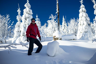 Man standing on snow covered landscape against sky