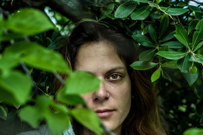 Close-up portrait of woman standing amidst plants