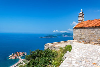 Church by sea against blue sky