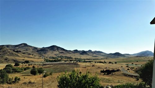 Scenic view of landscape and mountains against clear blue sky