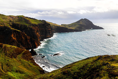 Scenic view of sea and mountains against sky