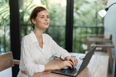 Young woman using laptop at table