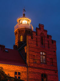 Low angle view of illuminated building against sky at night