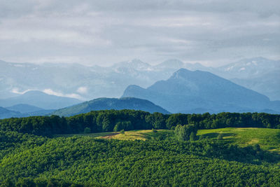 Scenic view of valley and mountains against sky