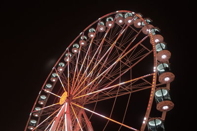 Low angle view of illuminated ferris wheel against sky at night