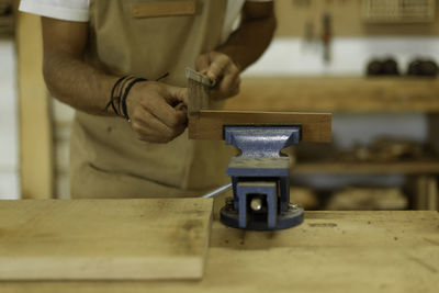 Midsection of carpenter working at workshop