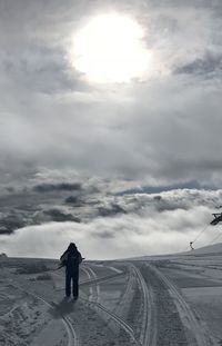 Rear view of man standing on snow covered land