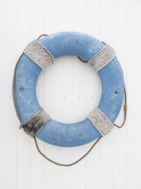 Blue lifebuoy with rope on white wooden background. symbol of travel and vacation. rescue device.