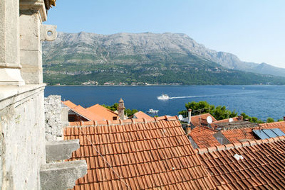 Buildings by sea against clear sky