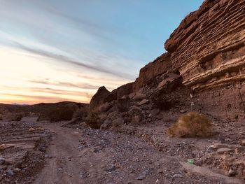 Rock formation on land against sky during sunset