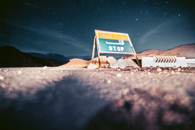 Close-up of sign against sky at night