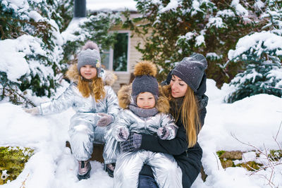 Portrait of smiling woman sitting on snow