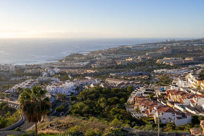 High angle view of townscape by sea against sky