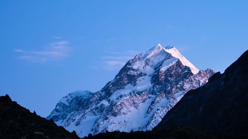 Scenic view of snowcapped mountains against blue sky