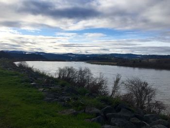 Scenic view of lake against cloudy sky