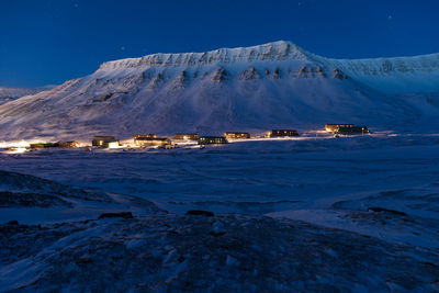 Snow covered mountains against blue sky at night